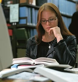 Photograph of a student at a computer in the library