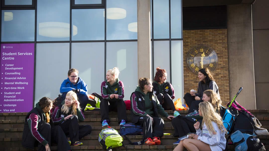 Students sitting on the steps outside the Charles Wilson Building